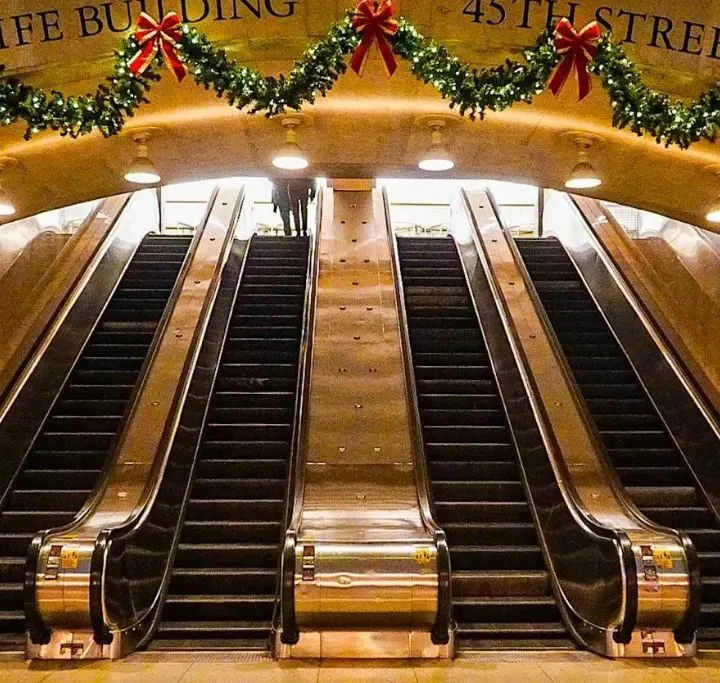 Garland with red bows hanging above the escalators at Grand central terminal in NYC.