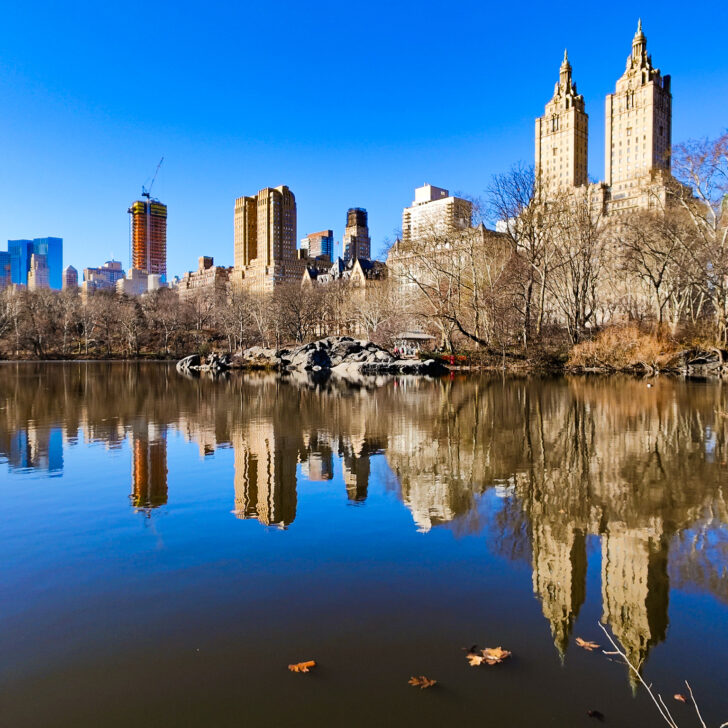 A view of Central Park in the winter with the skyscrapers on the West Side being reflected in the lake near the Ramble.