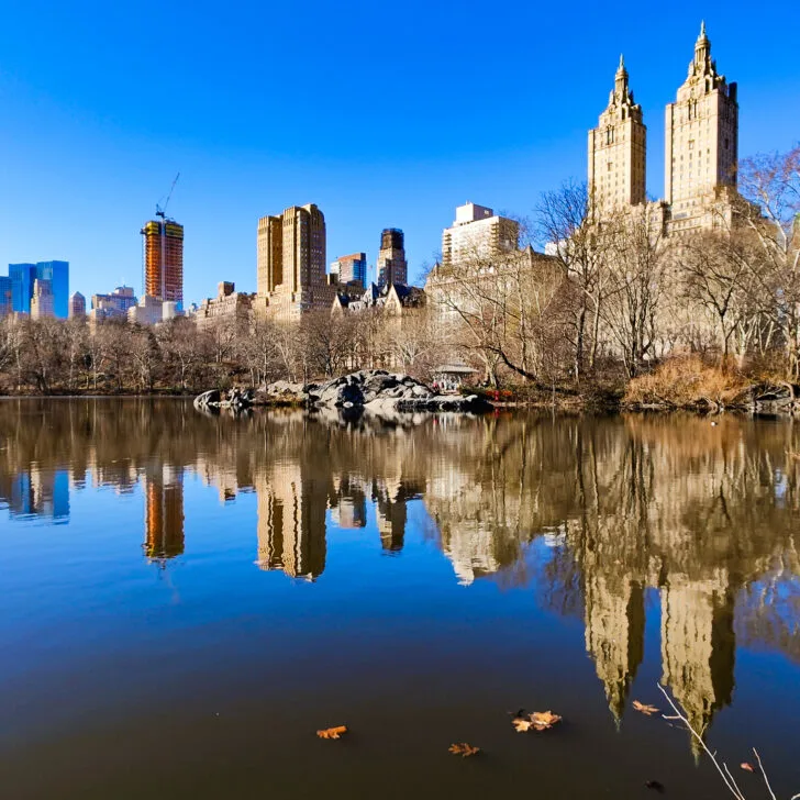 A view of Central Park in the winter with the skyscrapers on the West Side being reflected in the lake near the Ramble.