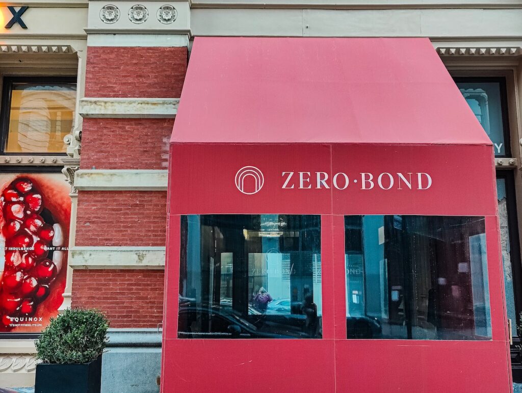Zero Bond is one of the best celebrity restaurants in NYC that sits inside a historic brick building. It has a red awning and box with the name of the restaurant on it that protects the door from the cold in the winter. 