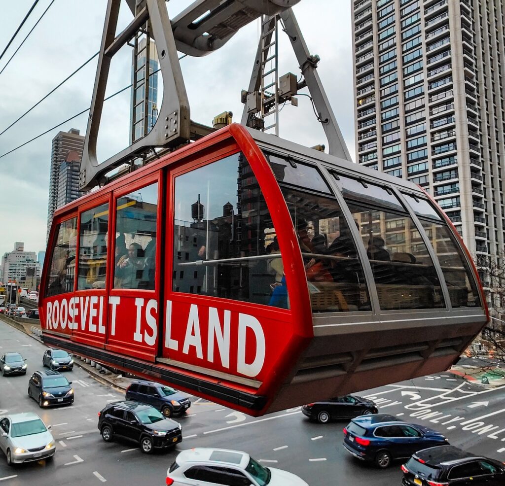 A view of the red Roosevelt island tram hugh above NYC.