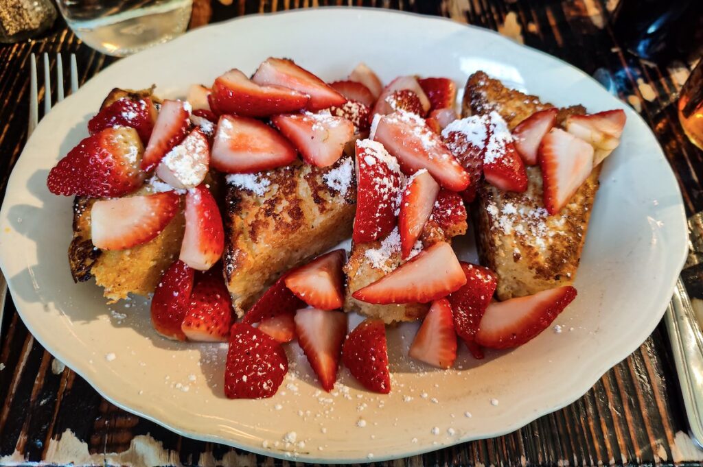 View of strawberry French toast on a white plate from Jacob's Pickles.