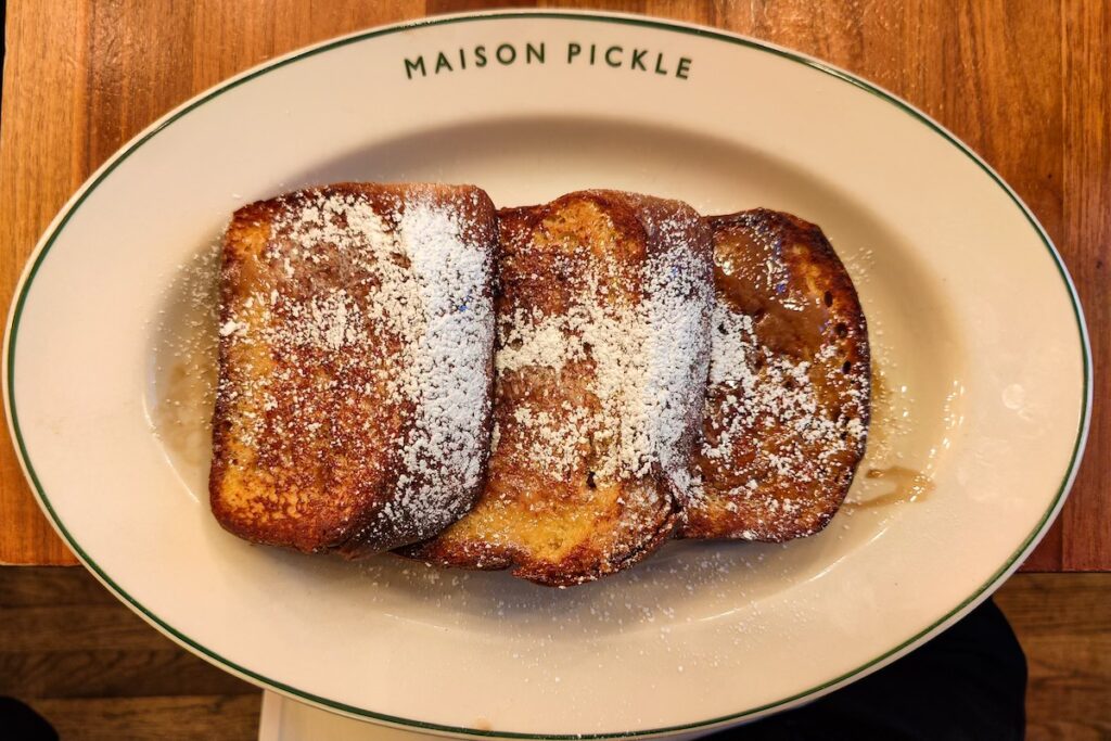 Aerial view of French Toast from Maison Pickle with powdered sugar on top.